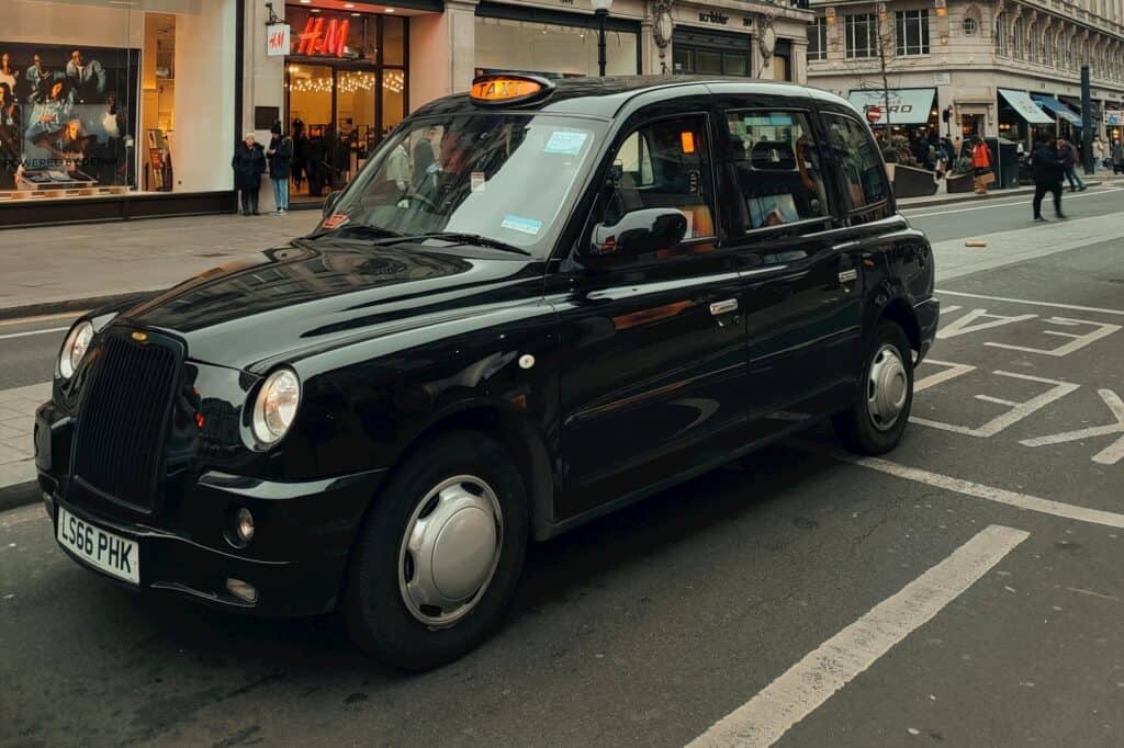 A black taxi in front of a shop
