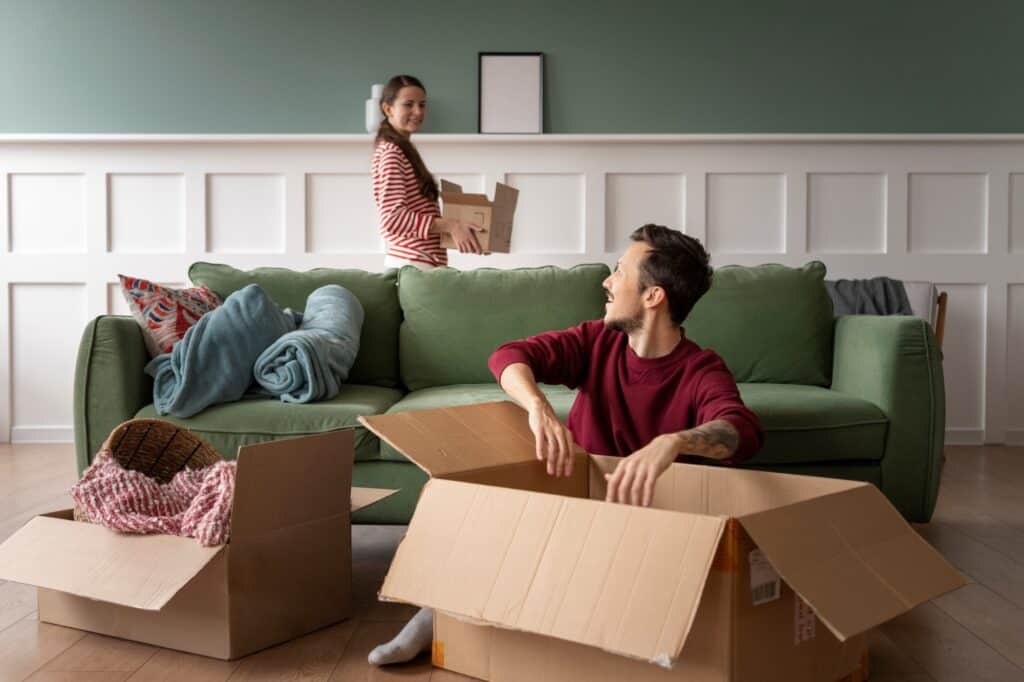 A couple unpacking boxes in the living room