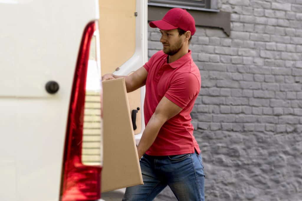 A man with a van loading a box into the van