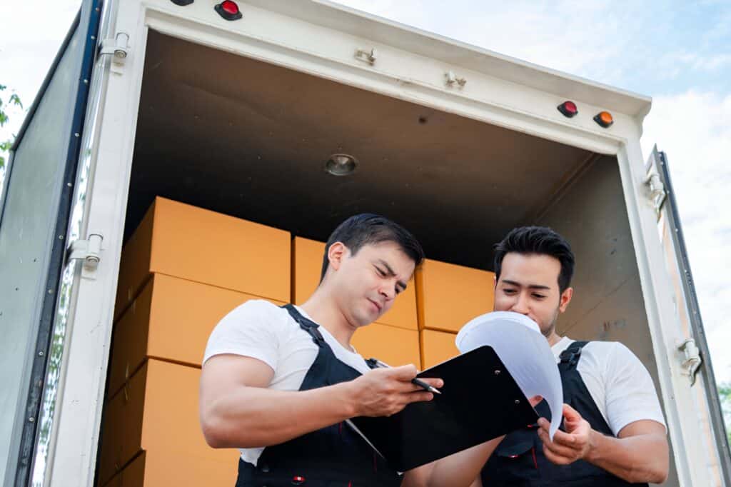 Traditional home removals crew at the back of the truck checking the inventory
