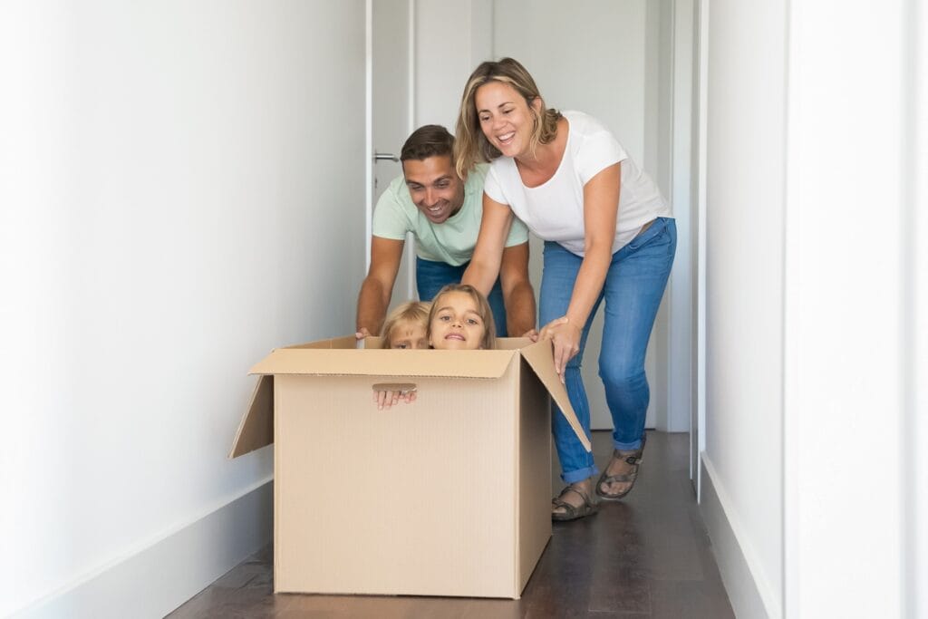 A young family playing with cardboard after the move