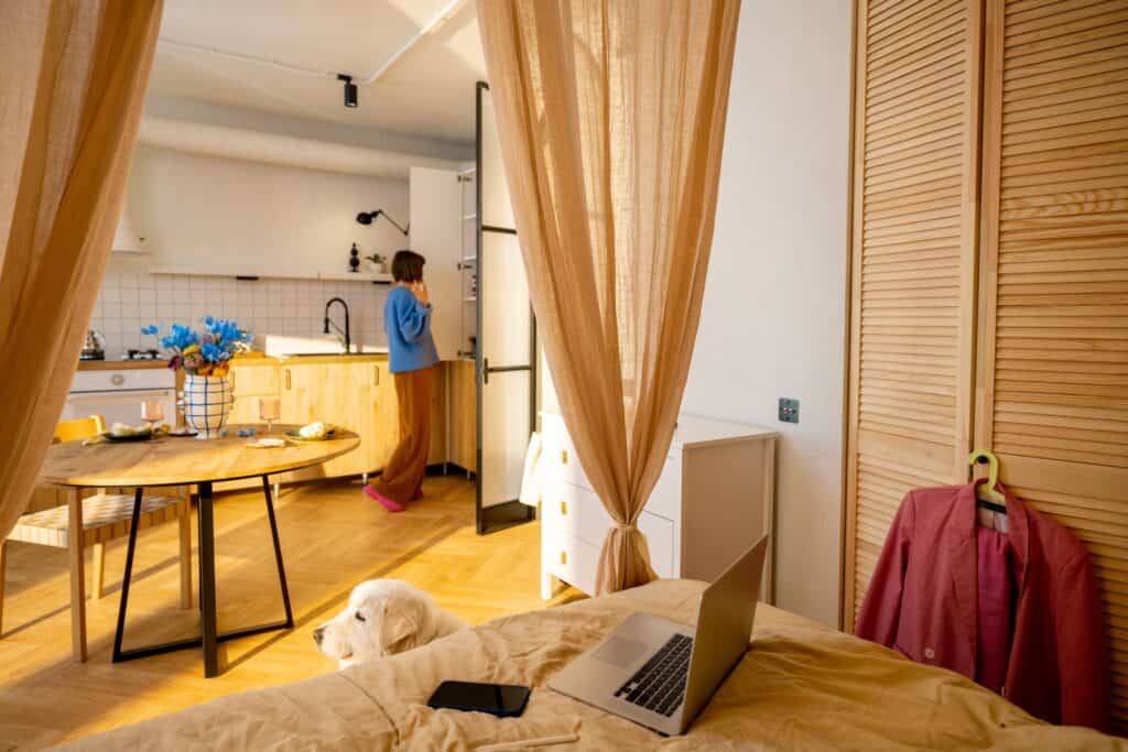 A woman and her furry friend in a studio flat complete with house furniture