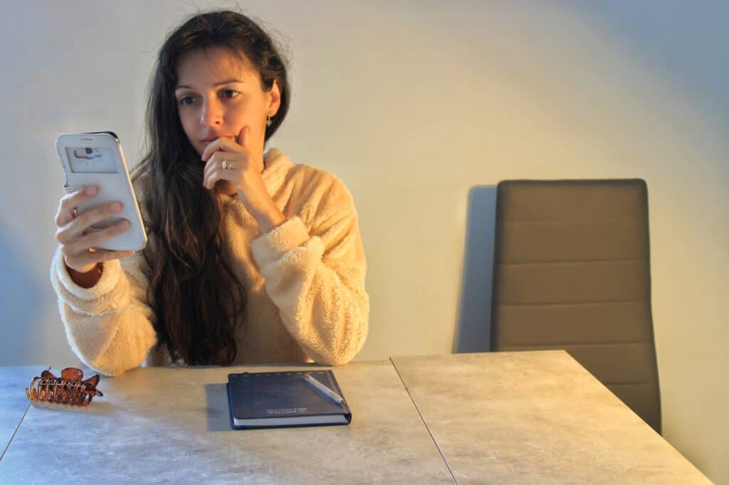 A woman in the dining area getting quotes from man and van services on her phone